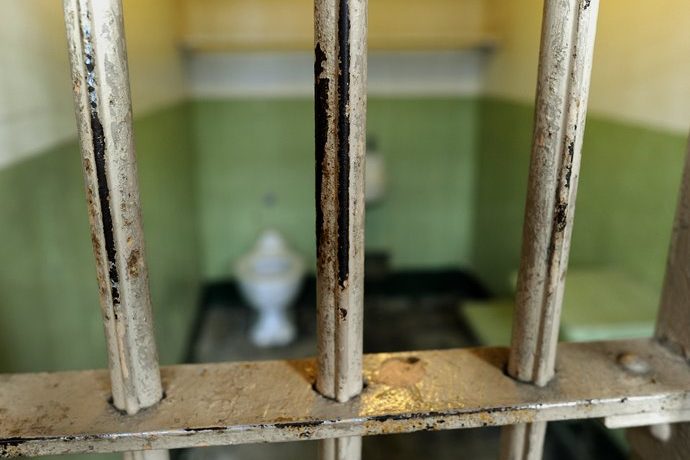 A photo of jail bars with a view showing inside the cell