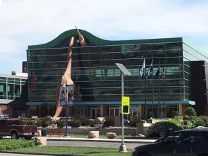 The outside of the children's museum with a dinosaur sticking out.