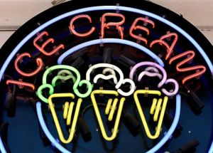 A neon Ice Cream sign hanging in front of a shop