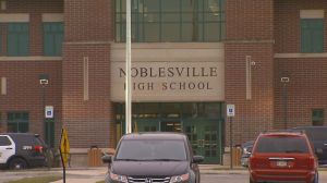 A photo of Noblesville High School with cars parked out front