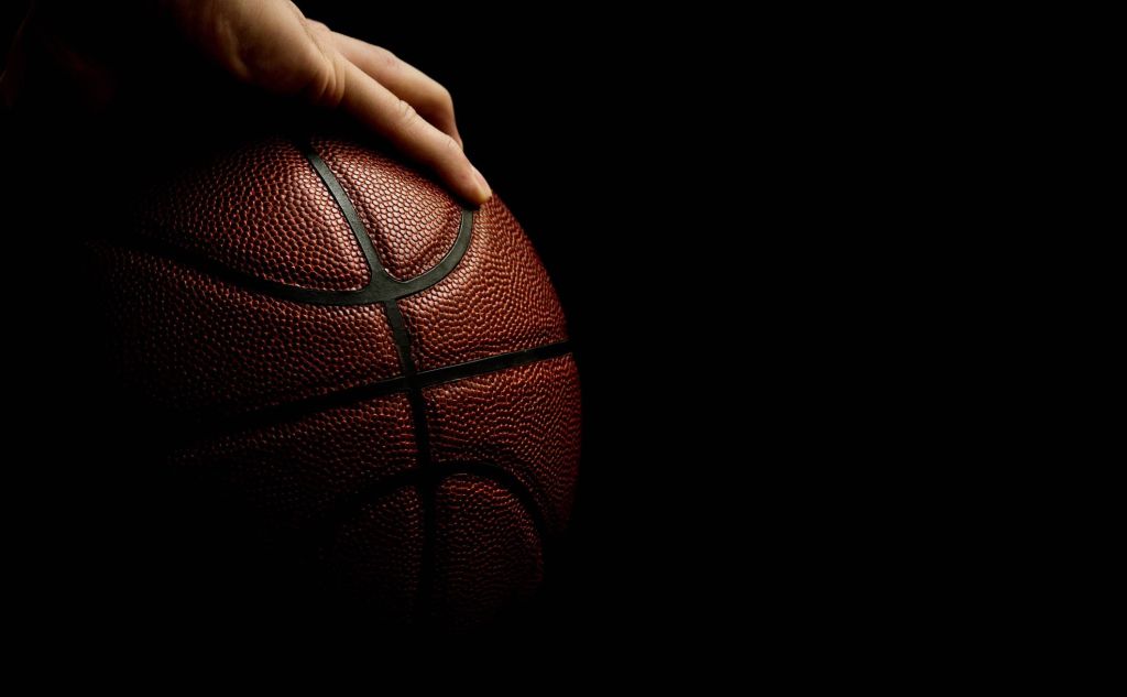 A man's hand palms a basketball