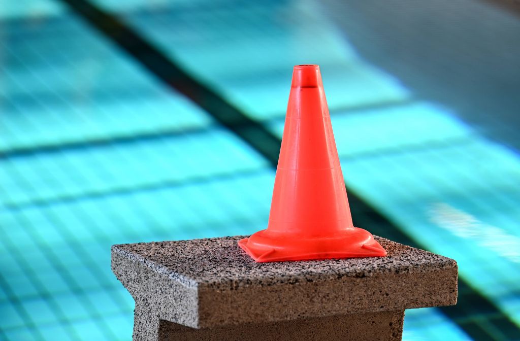 A cone on a block by a swimming pool