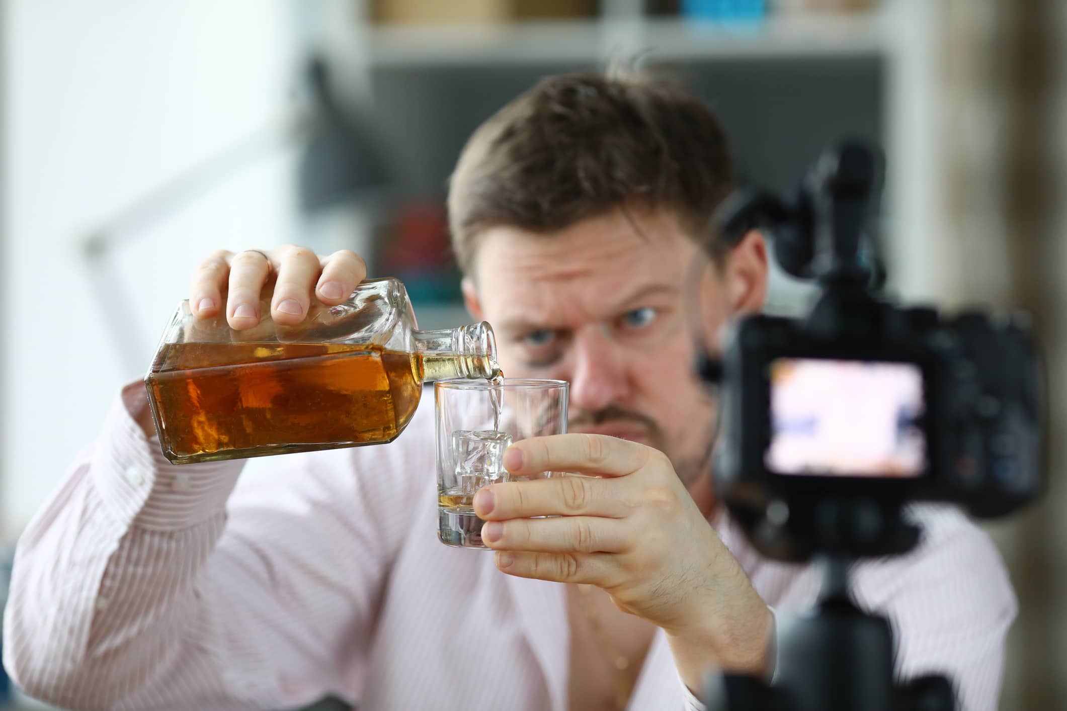 A man pours himself a large glass of whiskey.