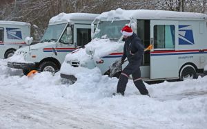 Santa to the rescue, a postal mailman helped to shovel out a stuck mail truck for a fellow mailman at the Milton Post Office in the early morning on Dec. 18, 2020 in Milton, MA. (Photo by David L. Ryan/The Boston Globe via Getty Images)