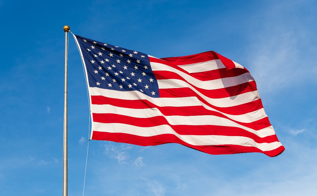 American Flag Waves Against a Blue Sky Background