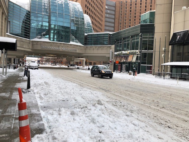 Illinois St. covered with snow piles under the Indianapolis Arts Garden