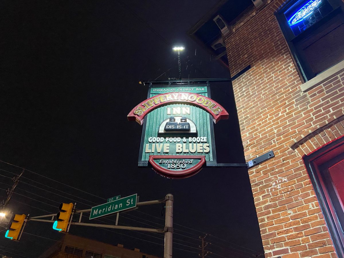 A picture of the front of the Slippery Noodle Inn, specifically the hanging sign on the corner of the building.