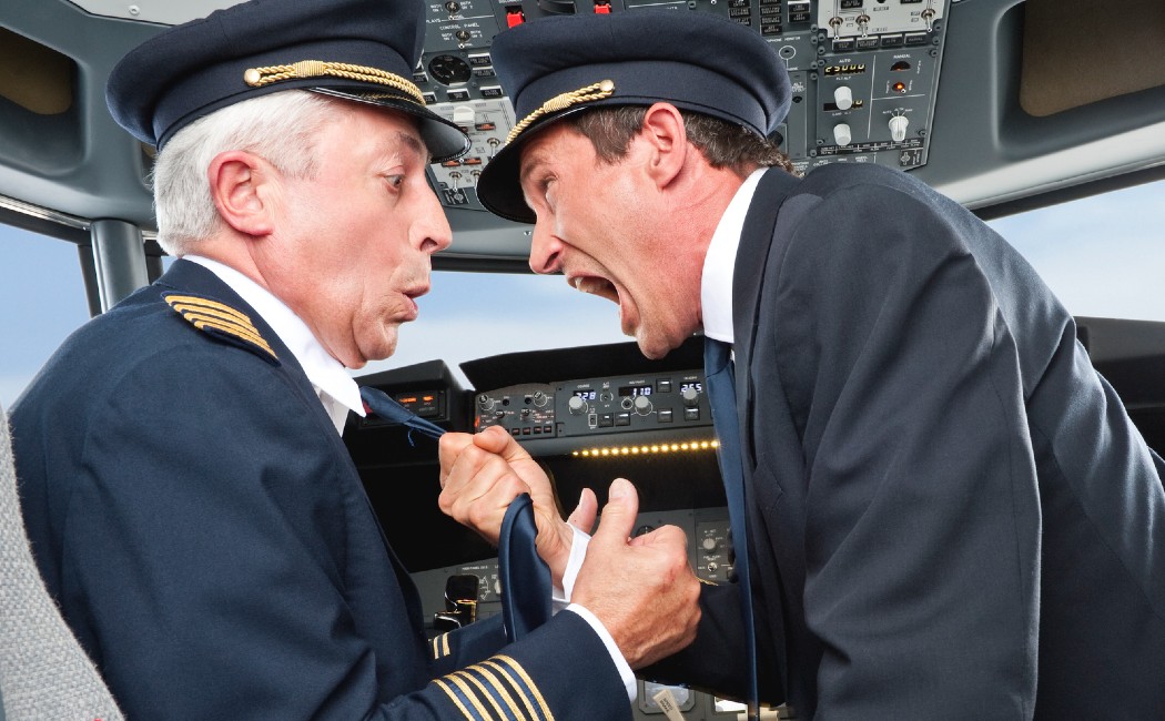 Pilot and Co-Pilot fight in cockpit of airplane.
