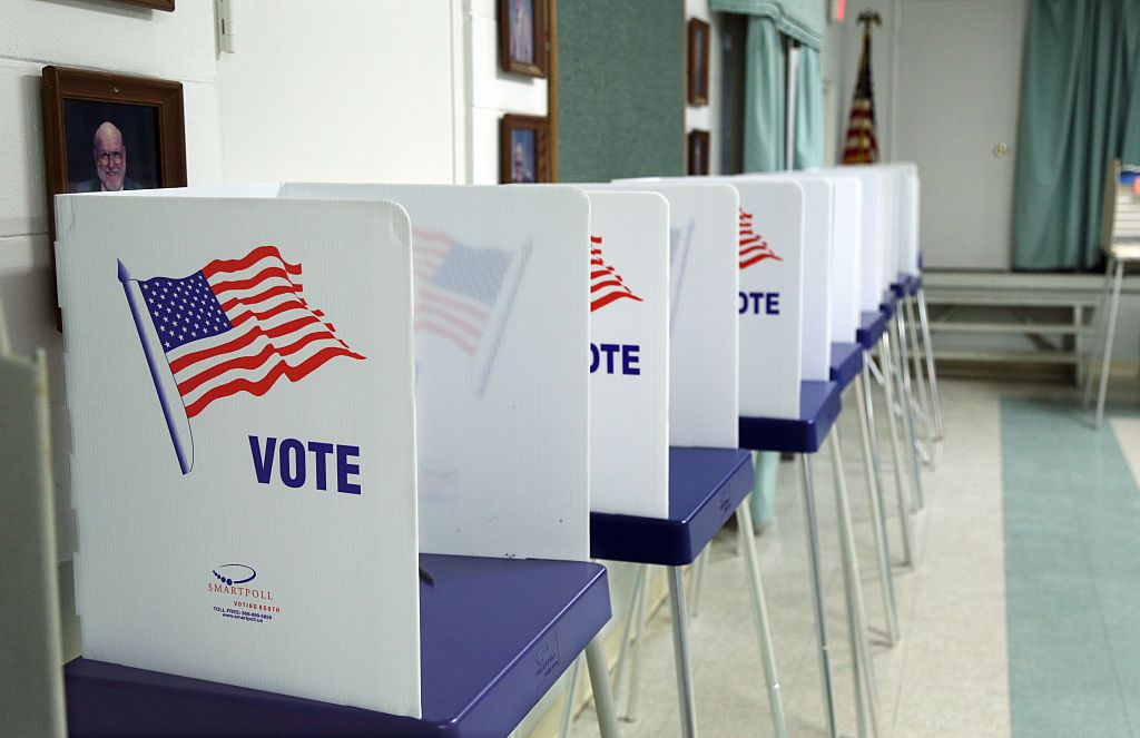 A photo of a voting booth with American flags