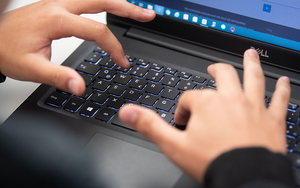Student typing on laptop