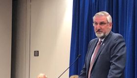 Gov. Eric Holcomb announces creation of a commission to review public health in Indiana, to be chaired by former Noblesville Sen. Luke Kenley (R) and former state health commissioner Judy Monroe (masked, in background).