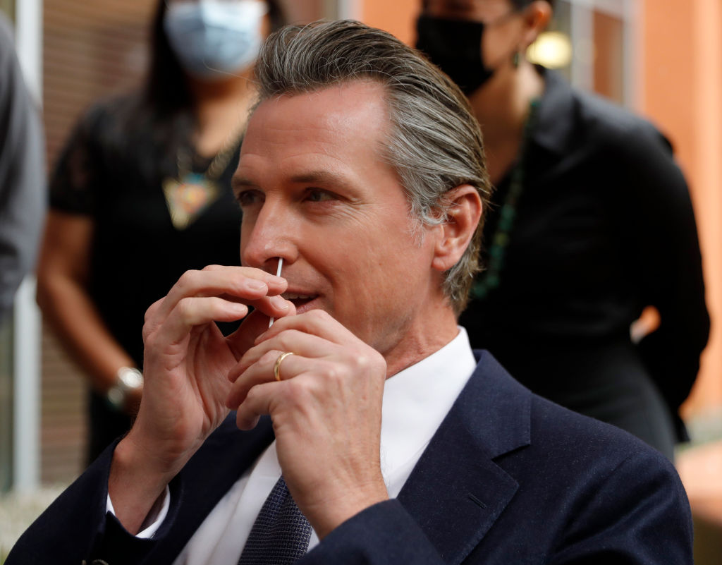 Gov. Gavin Newsom gives himself a Covid-19 PCR test at the Native American Health Center in Oakland, Calif., on Wednesday, Dec. 22, 2021. (Jane Tyska/Digital First Media/East Bay Times via Getty Images)