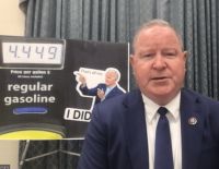 Congressman Larry Bucshon in front of a high gas prce sign