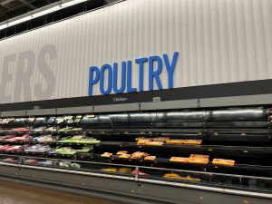 Photograph of the poultry section in a Walmart. The section shows the poultry section noticably empty compared to the other sections of food.
