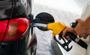 Pumping gas at gas pump. Closeup of man pumping gasoline fuel in car at gas station. Man's hand refueling car at gas station