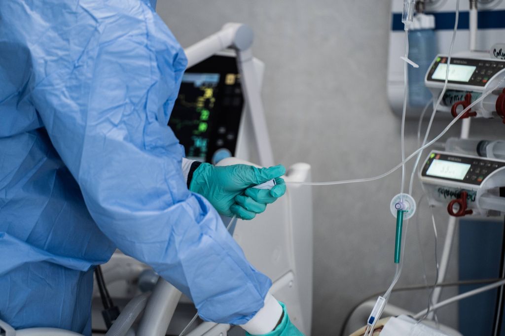 doctor wearing protective gear while taking measurements at a hospital
