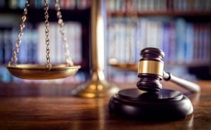 A judge's gavel and law books are seen in a courtroom.