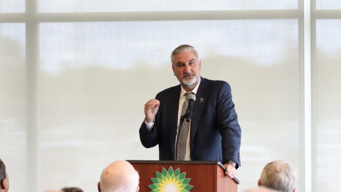 Gov Eric Holcomb dressed in a suit at a posium