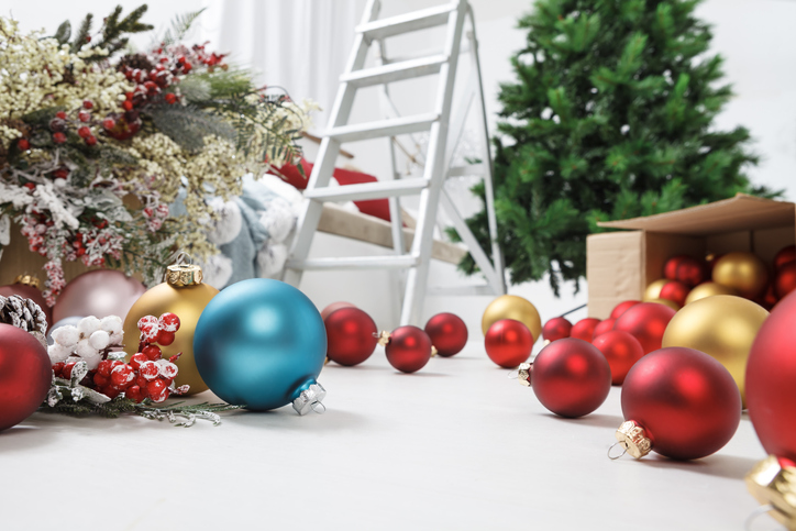Merry Christmas holidays time concept. Prepare the christmas tree. Living room filled with Boxes of bright colored balls and various decorations, with ladder and green fir tree in the background.