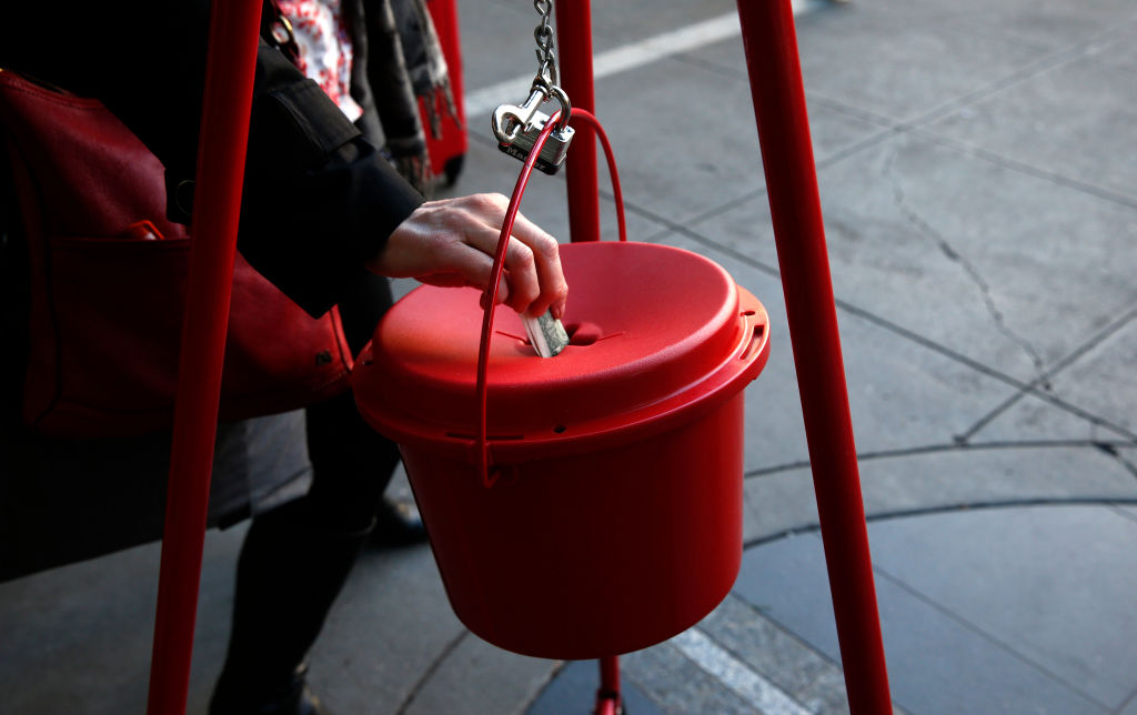 A shopper drops a donation into Jordan Broome's Salvation Army red kettle in front of Macy's across from Union Square in San Francisco, Calif. on Friday, Dec. 16, 2016