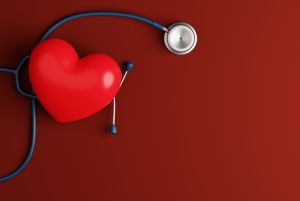 Heart and stethoscope on a dark background.