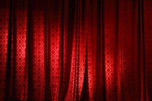 Closed red curtain on the stage of theater.