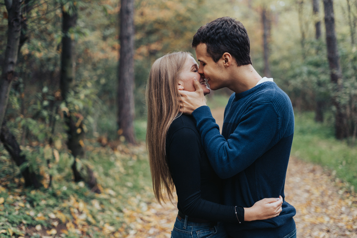 Romantic young couple kissing in a forrest