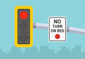 Traffic regulations. Close-up view of a traffic signal and "no turn on red" sign.