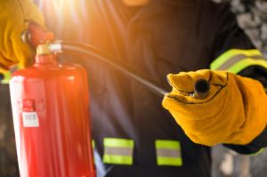 Close up hand Fireman using fire extinguisher fighting,Romania