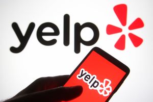 In this photo illustration a Yelp logo is seen on a...