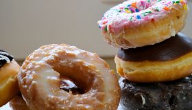 Assortment of donuts of different flavors in a box. Close-up of tasty doughnuts with sprinkles on table