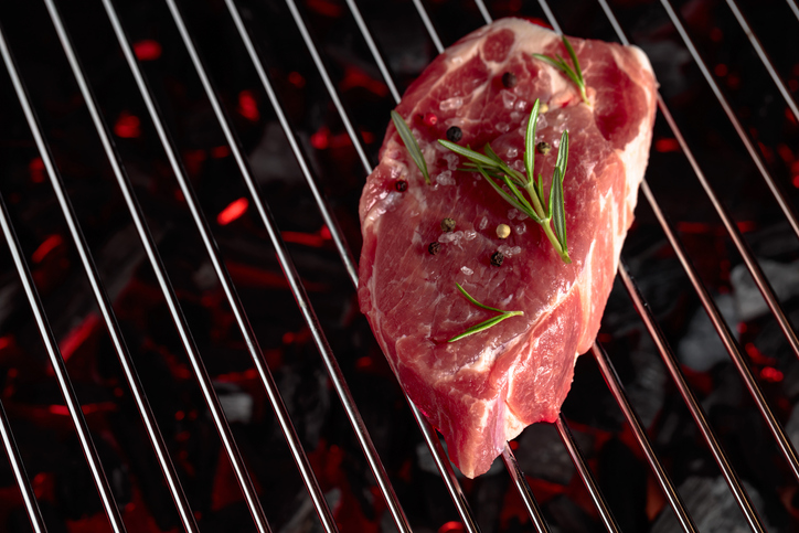 Raw steak on a grill.