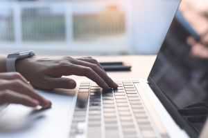 Woman hand typing on keyboard, online working on laptop computer