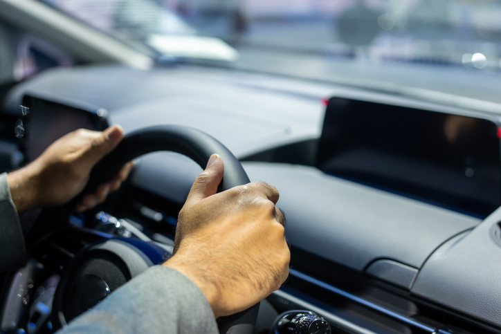 Young man getting new car hand is holding the steering wheel of the car Safe driving travel.