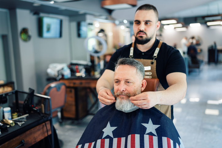 Professional skilled barber working in his barbershop