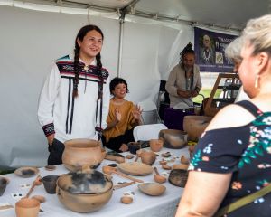 Artist Brandon Adriano Ortiz (Taos Pueblo) discusses his pottery with a marketgoer at last year’s Eiteljorg Museum Indian Market and Festival in downtown Indianapolis.