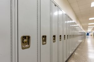 Empty middle school or high school hallway with gray student lockers