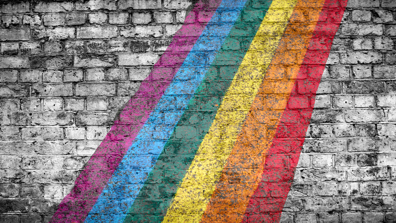 LGBT community flag on a white and grey patinated brick wall in London, England, United Kingdom