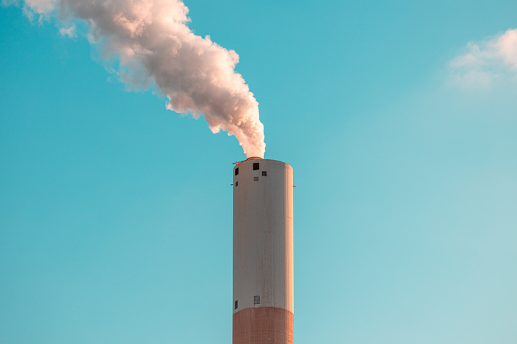 Power station steam rising against blue sky