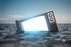 Tv set floating in a water. Concept of crisis of television broadcasting.