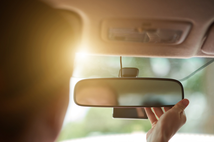 Driver Fixing Rearview Mirror
