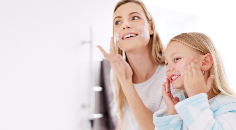 Skincare, mother and girl with cream, for natural beauty and bonding together in bathroom. Mama, daughter or child being happy, smile for cosmetics, organic facial and lotion for smooth skin and glow