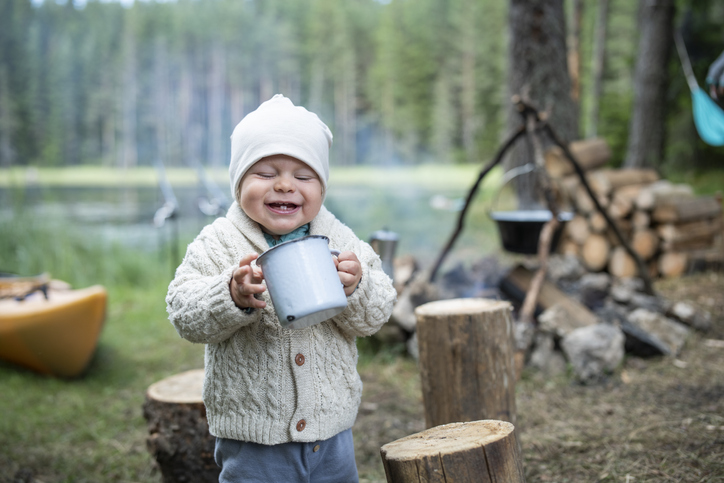 Happy baby boy on camping in nature.