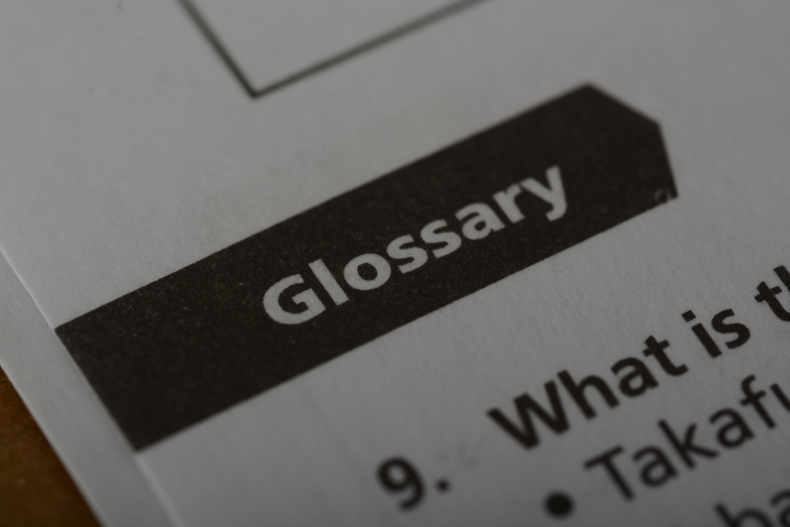 Close up view of the word GLOSSARY. A glossary is a specialized reference or dictionary that provides explanations, definitions, and explanations of terms, words, or phrases