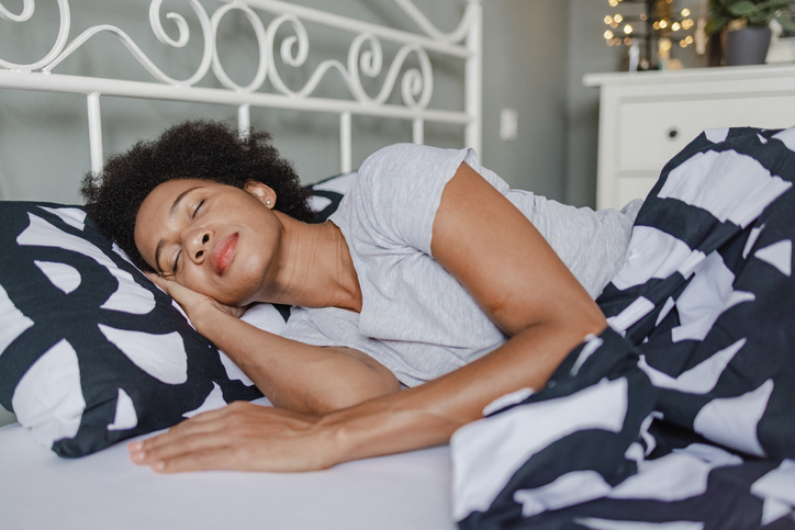 African-American woman sleeping in bed at home