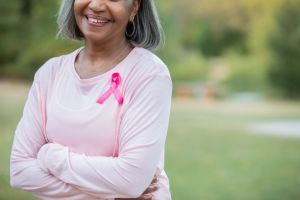 Pink ribbon on senior woman's shirt to raise breast cancer awareness