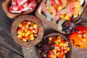 Bowls of Halloween Candy Corns and Jack O' Lantern on Wooden Rustic Table