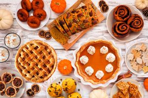 Autumn desserts table scene with a variety of traditional fall sweet treats over white wood
