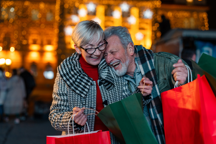 Senior couple in love having fun while shopping at Christmas market