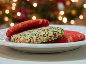 Close Up of Three Christmas Sugar Cookies Decorated with Red Sugar and Red, White, and Green Sprinkles